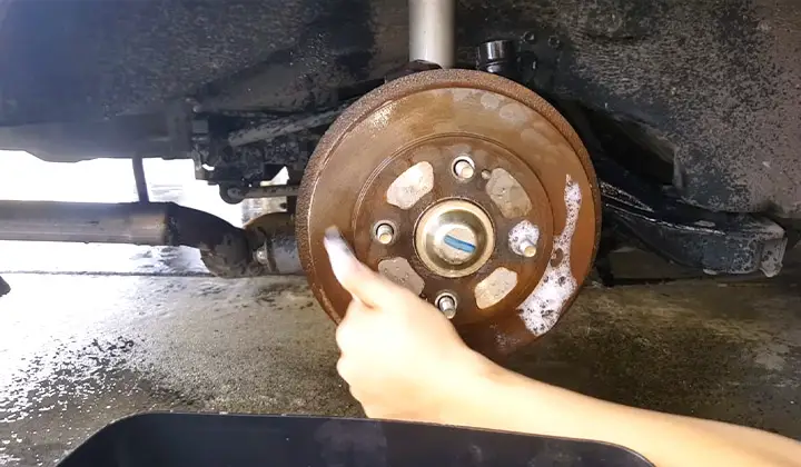  Using a brush to clean brake rotors