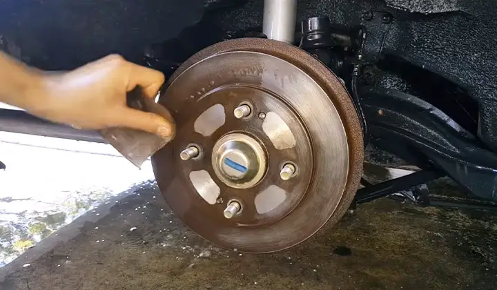 Using scrubbing pad to clean brake rotors